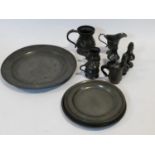 A collection of antique pewter items. Including plates, measures, pepper shaker, jug and tankards.