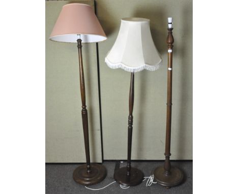 An oak standard lamp, 155cm high, and two mahogany lamps