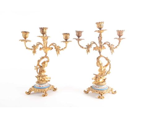 A pair of 19th-century ormolu figural three-branch candelabra. Each with three flower head scones issuing from vines. Held al