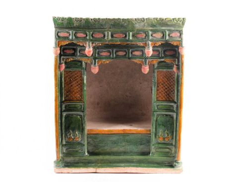 A Chinese pottery Sancai glazed shrine, late Ming, modelled as a temple, with scroll pediment above rectangular panels and ba