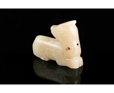 A jade recumbent deer, looking back on itself, with archaic style incised decoration, pierced at the neck, 5cm long, 3.6cm hi