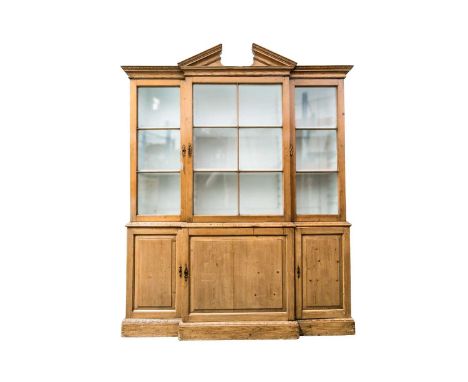 A George III pine breakfront cupboard bookcase of small proportions, with architectural pediment above three "Window Pane" gl