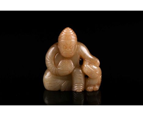 A Chinese jade figure group, carved as a seated man holding a diapered roundel, his left arm around a shi shi, 5.8cm highCond