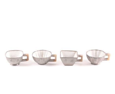 Four Chinese inscribed pewter, Yixing and jade tea cups, Qing, late 19th century, of varying shape, each with a white crazed 