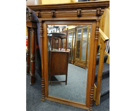 EARLY 20TH CENTURY MEDIEVAL-STYLE OAK OVERMANTEL MIRROR, ogee cornice with four carved masks, bevelled mirror between turned 