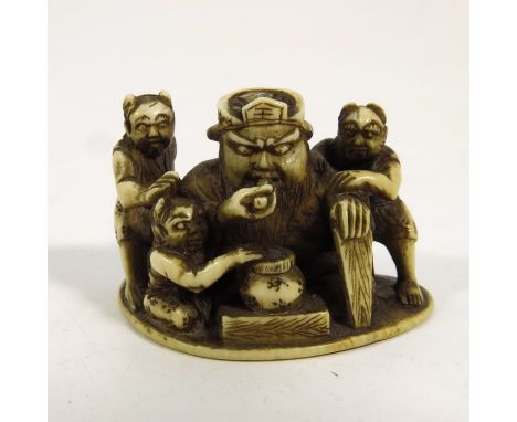 λ A 19th century Japanese ivory netsuke, Meiji, modelled as a figure group with man and horned imps, 5cm