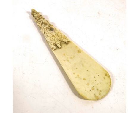 λ A 19th century Japanese carved ivory shoe horn, the handle with knotty flowering trunk, 19cm long
