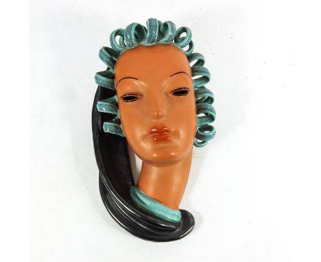 An Art Deco face mask, in the style of Kurt Goebel for Goldscheider, terracotta glaze with curled hair and scraf, 28cm long