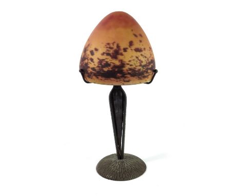 A French Art Deco lamp, in the style of Louis Majorelle and Daum, the orange mottled mushroom domed shade on a textured wroug