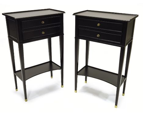 A pair of black lacquered side cabinets, French, restored circa 1930, the tapered supports with open shape shelf and two long