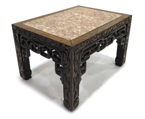 A Chinese hardwood stand, late 19th century, rectangular form set with pink marble, reticulated key fieze and blind carved fo