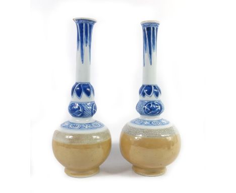 A pair of Japanese porcelain vases, probably 18th century, acorn knopped globe and shaft form, the lower half of the body in 