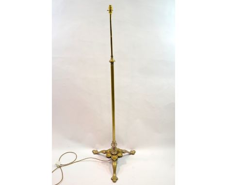 An Arts and Crafts brass and electroplated standard lamp, circa 1890, the tripod base with trefoil feet below a stylised peta