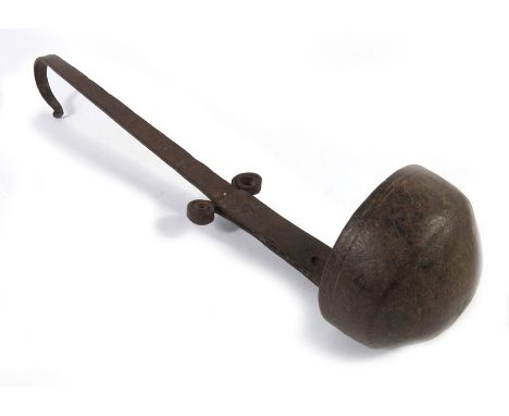 An 18th century wrought iron ladle or lamp, the hemispherical bowl on a tapered and riveted stem with curled decoration to th
