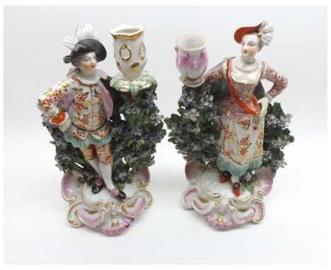 A pair of 19th Century Derby Candlestick Figures of lady and gent, applied with puce painted sconces and with floral encrusta