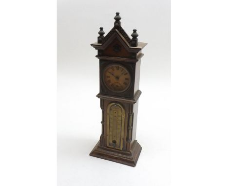 An early 20th Century Walnut and Brass mounted Desk Timepiece modelled in the form of Longcase Clock with arched pediment wit