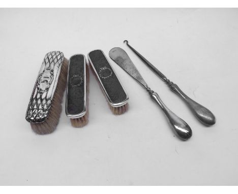 A Mixed Lot comprising: three assorted Silver-Backed Dressing Table Brushes, together with a further Silver-Handled Button Ho