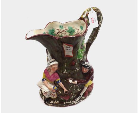 19th Century Staffordshire Fair Hebe Jug decorated with figures around a tree trunk, restoration to handle and paint flaking 