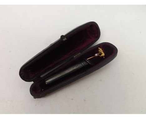A Cased high grade yellow metal Stick Pin, the end formed as a dog standing on a pearl, together with a Birmingham hallmarked