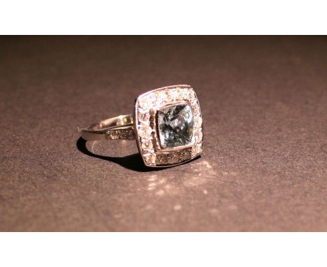 An 18ct. White Gold Aquamarine and Diamond Ring of square form with a central aquamarine surrounded by diamonds, approximatel