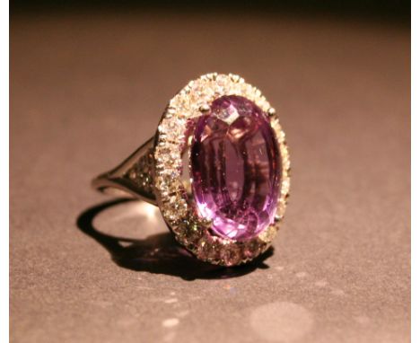 An 18ct White Gold Large Amethyst and Diamond Ring, with an oval amethyst surrounded by diamonds within a pierced setting