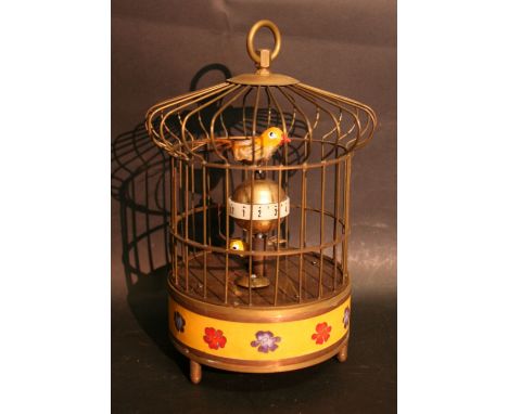 A Brass Bird Cage Clock, in the form of a bird upon a globe above an enamel base, 21 cms high