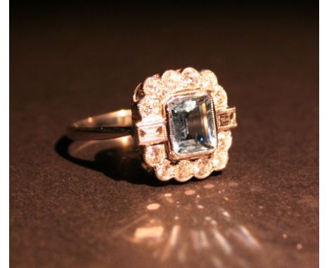 An 18ct. White Gold Aquamarine and Diamond Ring, with a central rectangular aquamarine surrounded by diamonds and with baguet