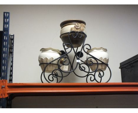 THREE CERAMIC PLANTERS ON A CAST METAL STAND