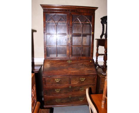 A George III mahogany bureau bookcase, the upper section enclosed two glazed doors, over base fitted bureau with two short an