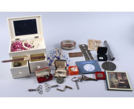 An assortment of costume jewellery, including beaded necklaces, cufflinks, clock keys, an autograph book, and other items