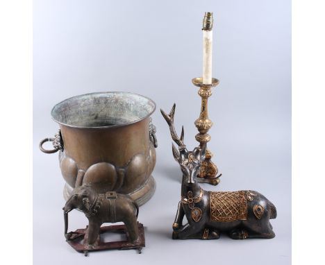 A copper coal vase, a brass elephant, a giltwood table lamp and a wooden model of a reindeer