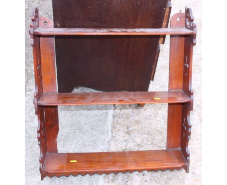 A Victorian mahogany three-tier open wall shelf with Gothic pierced sides, 23" wide, and a similar wall shelf, 24" wide