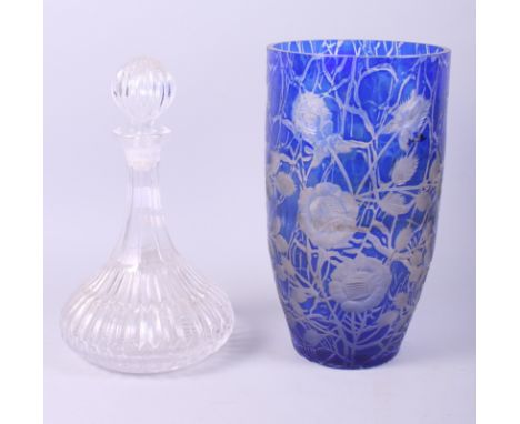 A blue overlaid glass vase with engraved floral decoration and a glass decanter with stopper