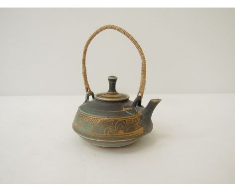MARY RICH (b.1940) A studio porcelain miniature teapot in green and gilt, cane handle. Impressed seal. Height to top of handl