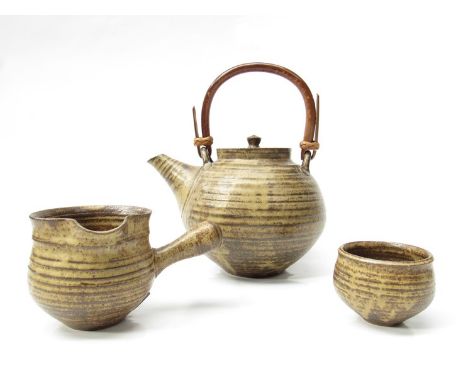 GWYN HANSSEN-PIGOTT (1935-2013) An early teapot made when she was Gwyn John, ash glazed with cane handle, matching jug and su