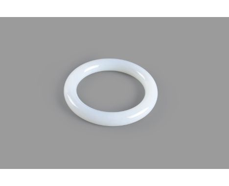 A white jade bangle, 20th century, unadorned, the stone of even white tone with cloudy inclusions,7.9cm diameter   白玉镯