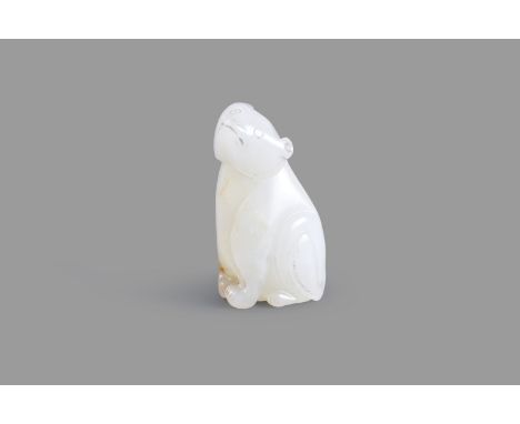 A Chinese white jade carving of a beast, seated, its head facing forward, the stone of white tone with honey russet inclusion