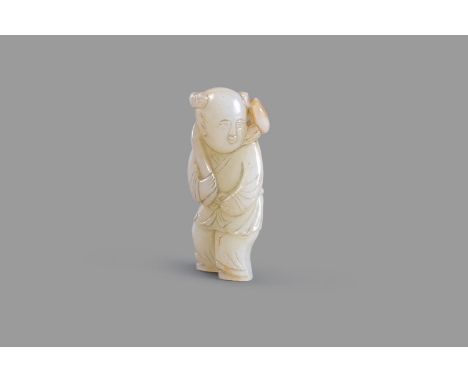 A white and russet jade carving of a boy, the standing holding a peach branch over his shoulder, his hair worn in two topknot