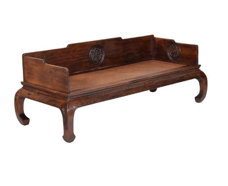 A Chinese hardwood 'Luohan' couch-bed, Qing Dynasty, possibly tieli wood, carved with dragons roundels, the whole raised on i