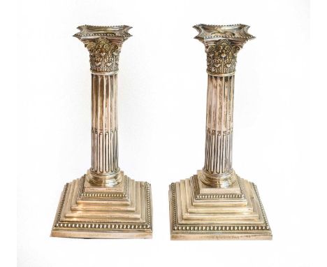 A Pair of George V Silver Candlesticks, each on stepped square base, the fluted stem with Corinthian column capital, filled (