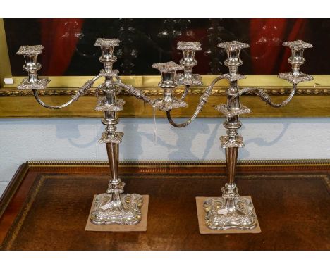 A Pair of Silver Plated Three-Light Candelabra, each on square base with foliage scrolls, 47cm high (2)