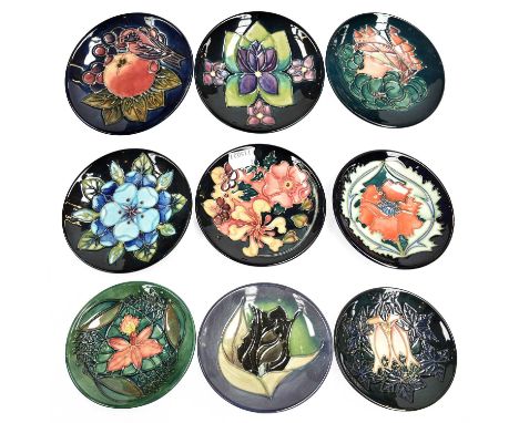 A collection of modern Moorcroft pottery coasters including Violet, Cluny and other patterns, each 12cm diameter (9)Condition