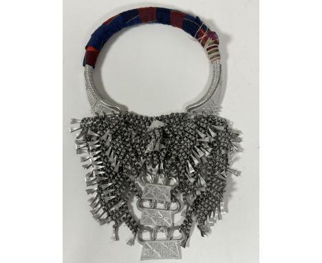 A North African aluminium triple stand coil chain and panel multiple stand necklace with fabric covered halter neck piece. (l
