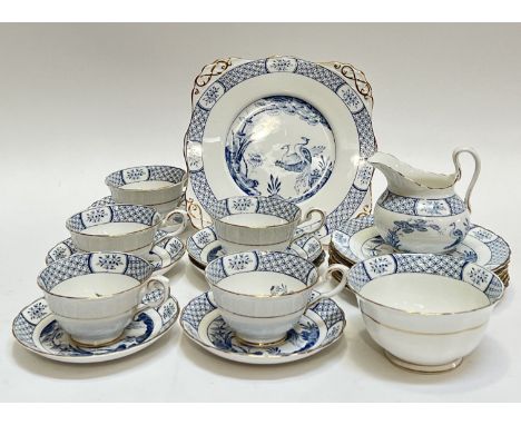 A part tea set of gilt blue and white Tuscan Bone China decorated with scenes of birds and trees in Eastern style, comprising