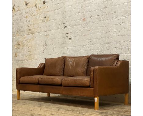 Habitat, a contemporary three seat sofa, upholstered in tan leather and raised on beech square section supports H72cm, W187cm