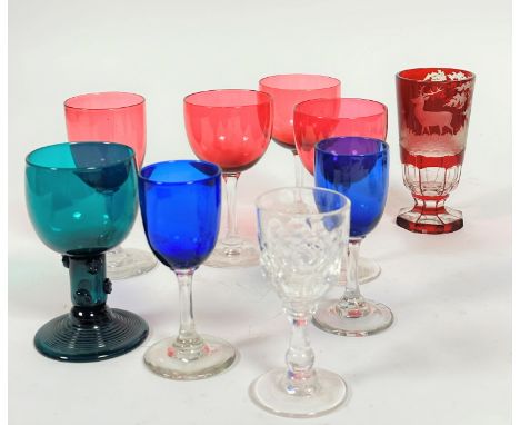 A collection of late 19th glass including three cranberry glasses on clear stems and another taller, a green German style rum