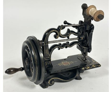 A Charles Raymonds late 19thc cast iron miniture table top manual sewing machine with black enamel and gilt decoration. (h 17