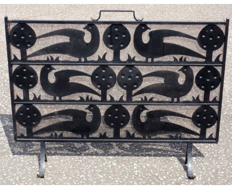 C F A Voysey style cast iron and wire mesh fire screen, the stylised design with 3 rows of flowers flanked by 2 birds, with a