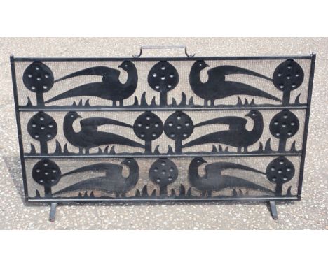 C F A Voysey style cast iron and wire mesh firescreen, the stylised design with 3 rows of flowers flanked by 2 birds, with an