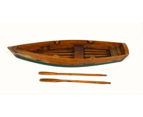 Stained pine model of a rowing boat with a pair of oars, L.53.6cm, (lacking 4 rollocks) 